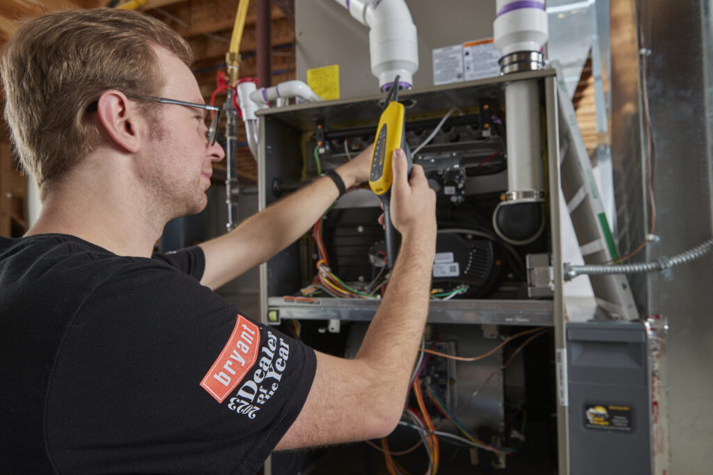 A Weather Changers employee working on a furnace heating system in the Denver metro area. 