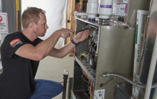 A Weather Changer technician ensuring a furnace in Denver metro area is cleaned and maintained.