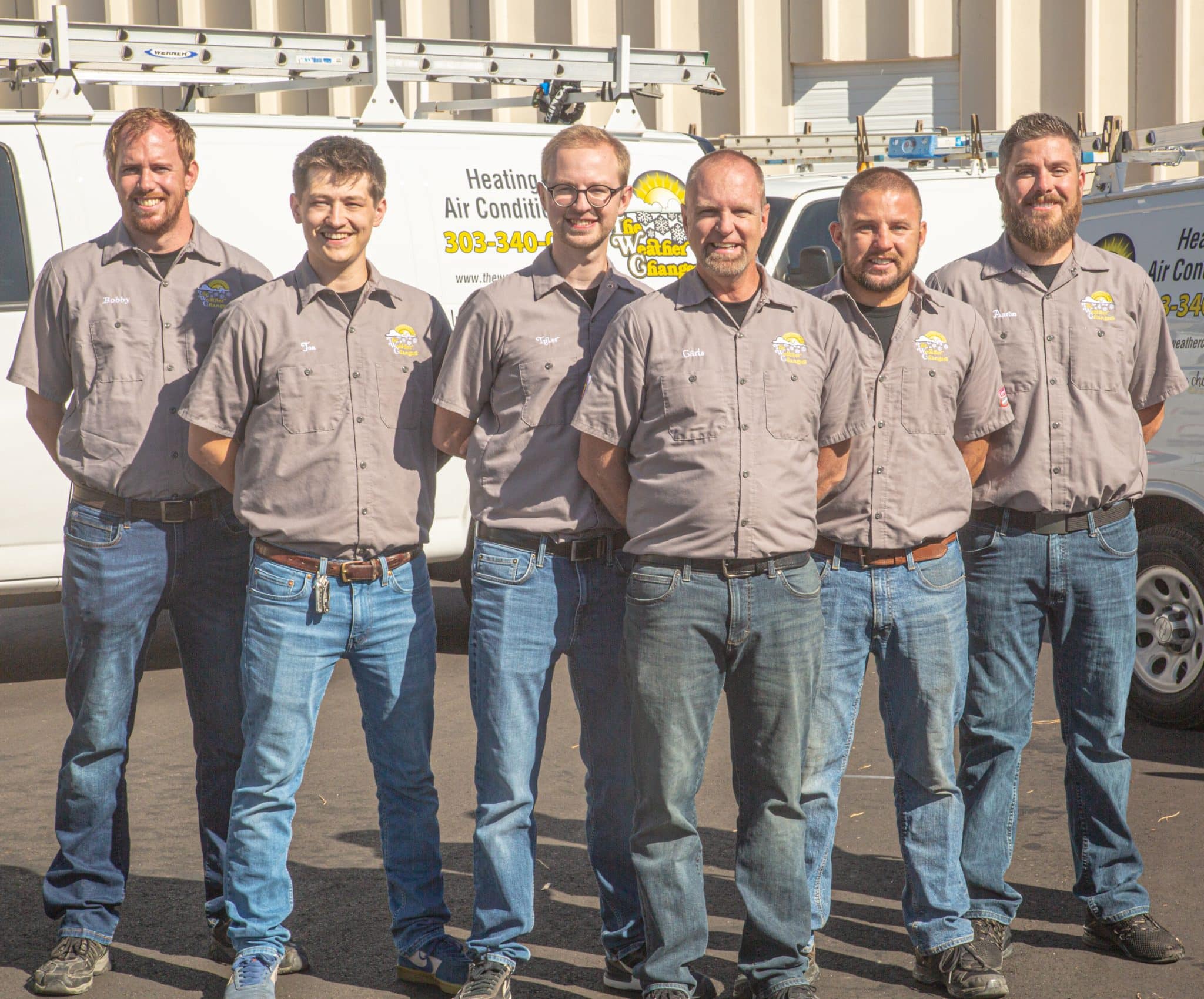 A group of smiling employees wearing Weather Changers shirts.