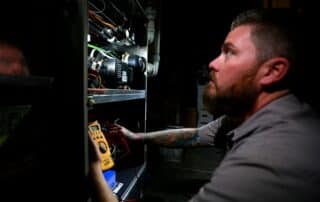 An employee wearing a Weather Changers shirt and working inside.