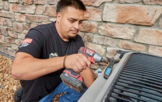 A Weather Changers technician working on a heat pump system.