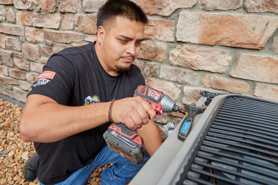 A Weather Changers technician working on a heat pump system.
