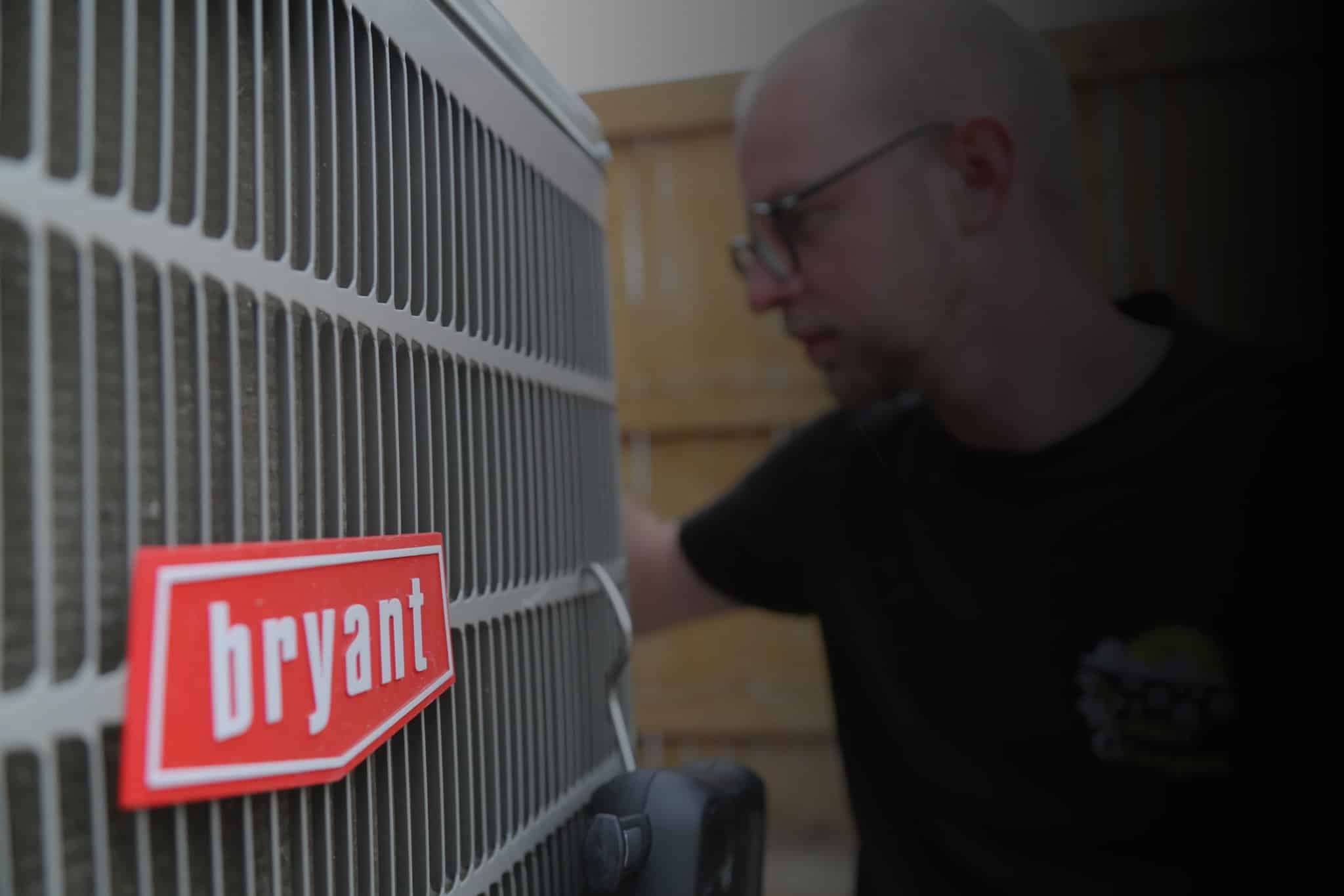 An employee working outside on a ac unit.