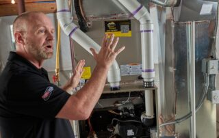 A Weather Changers technician discussing heat pump vs. A/C in Denver, CO.