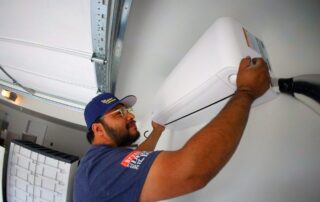 A Weather Changers technician installing a garage ductless system in Denver, CO.
