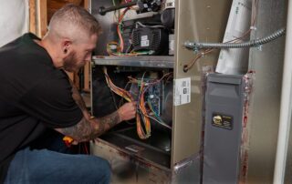 A Weather Changers technician servicing a furnace heater in Denver, CO.