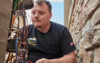 A Weather Changers technician working on an air conditioning system in Denver, CO.