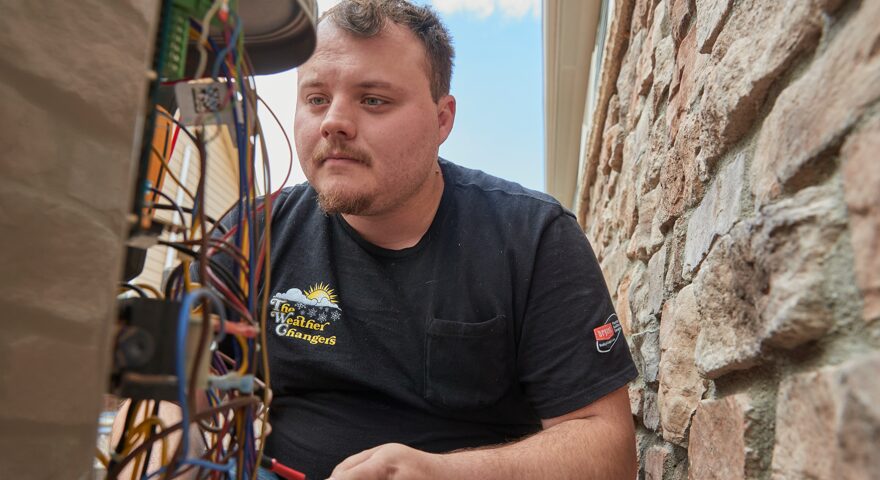 A Weather Changers technician working on an air conditioning system in Denver, CO.