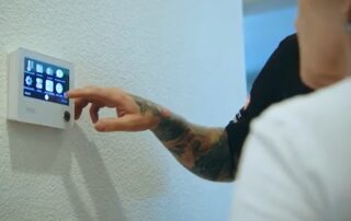 The Weather Changers technician helping a customer program a newly installed WiFi thermostat.