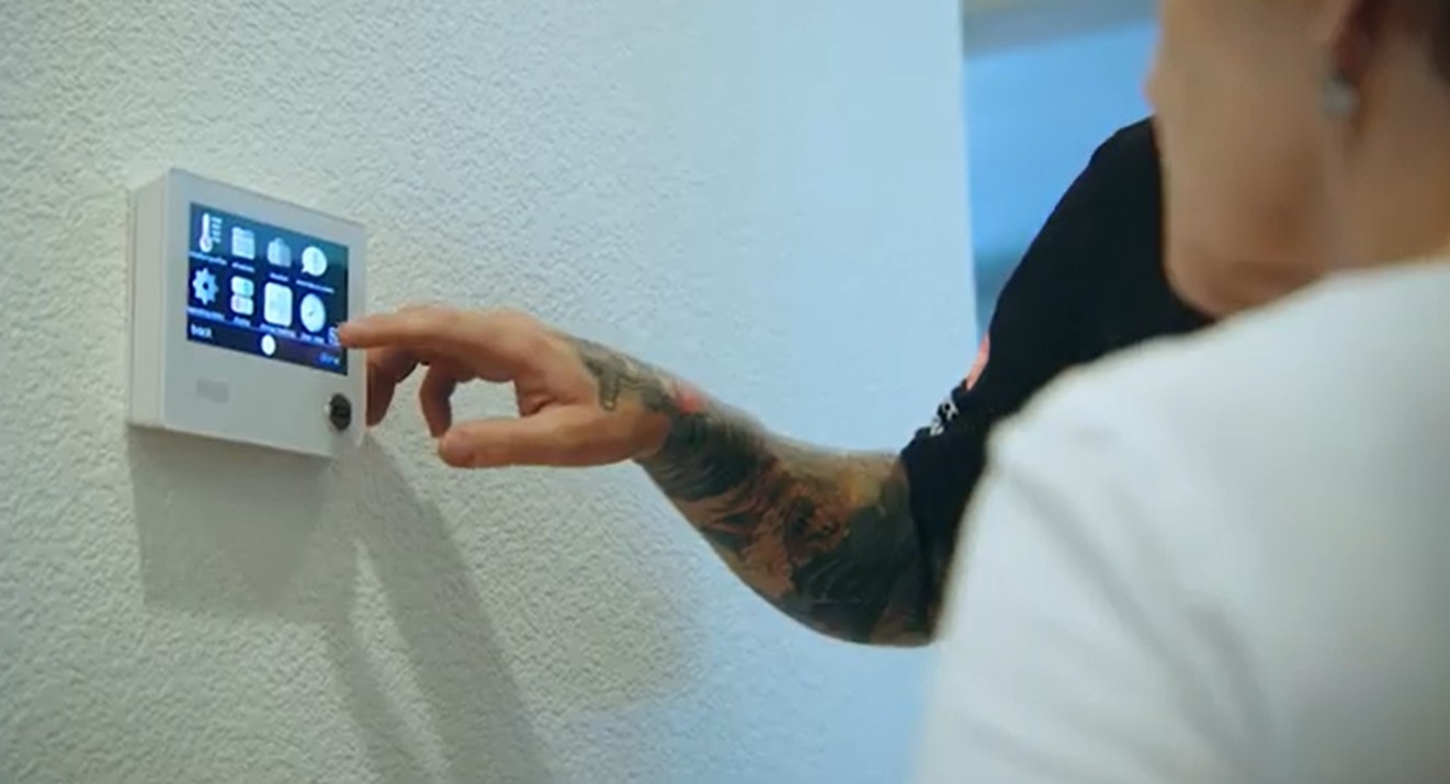The Weather Changers technician helping a customer program a newly installed WiFi thermostat.