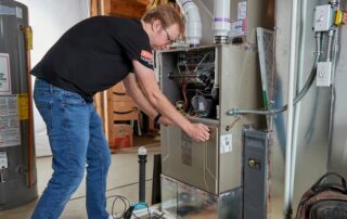 A Weather Changers technician working on a furnace heating system in Denver, CO.