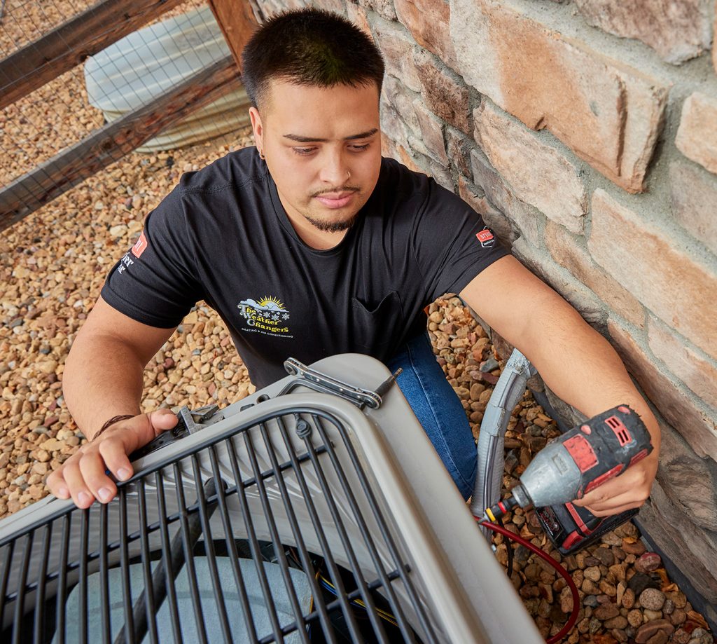 View from above of a technician working on a air conditioner outside