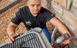 View from above of a technician working on a air conditioner outside